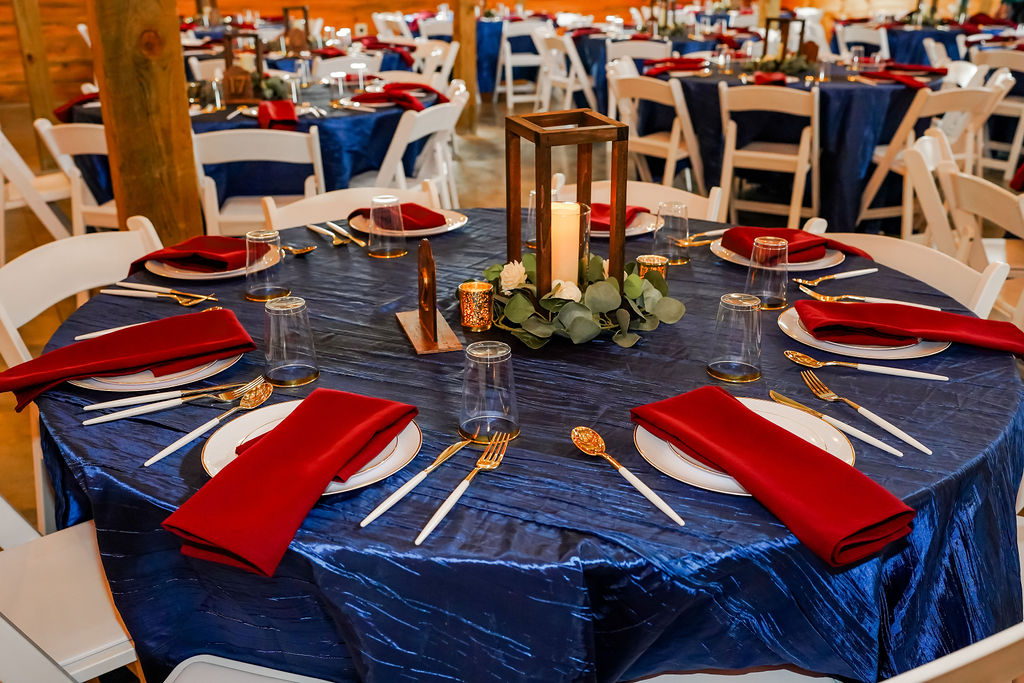Navy tables with burgundy napkins and wooden lantern centerpieces for Courtney & John's reception at Covey Creek.