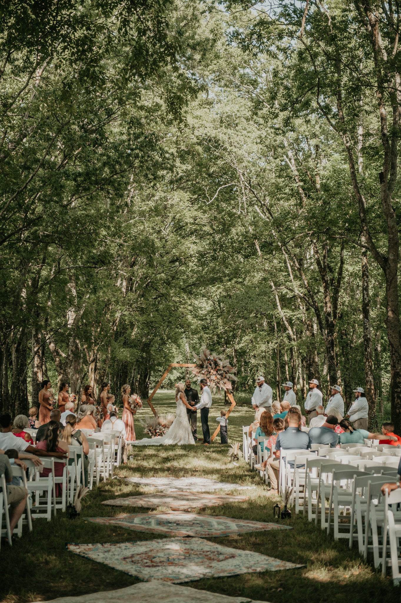 Hali & Kyle exchange vows under a hexagonal arbor at Covey Creek’s tree-canopy Tunnel of Love ceremony.