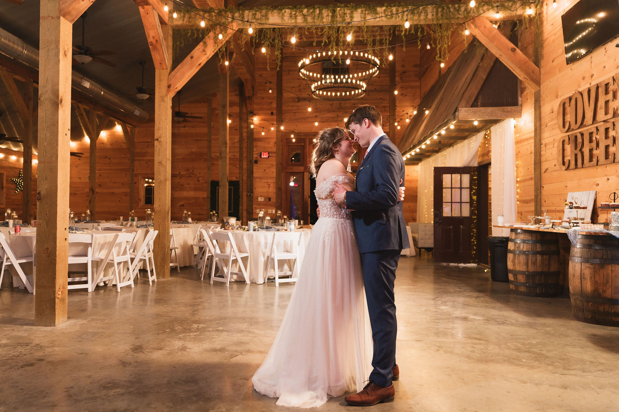 Ana & Carter slow dance in the barn under the chandelier with Covey Creek letters on the wall