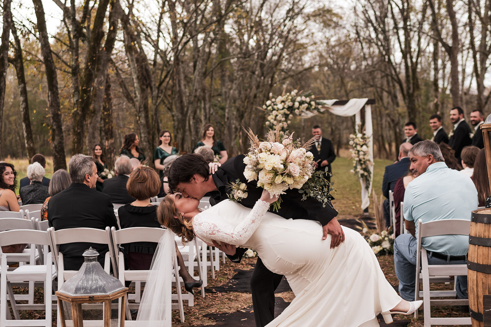Alex dips Isabelle for a kiss on the Tunnel of Love aisle at their Covey Creek outdoor ceremony.
