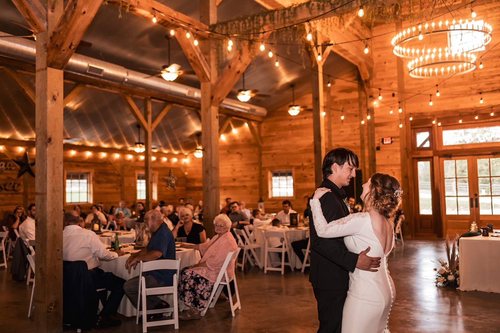 Isabelle & Alex share their first dance under chandeliers and string lights in the Covey Creek barn.