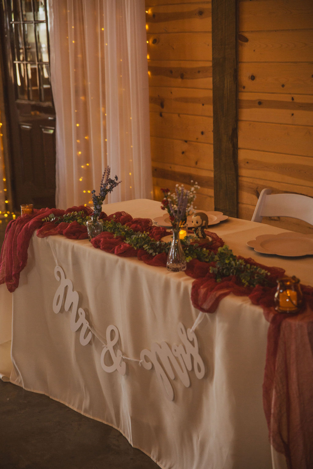 Jen & Alec sweetheart table with Mr & Mrs banner, burgundy runner, and candles at Covey Creek