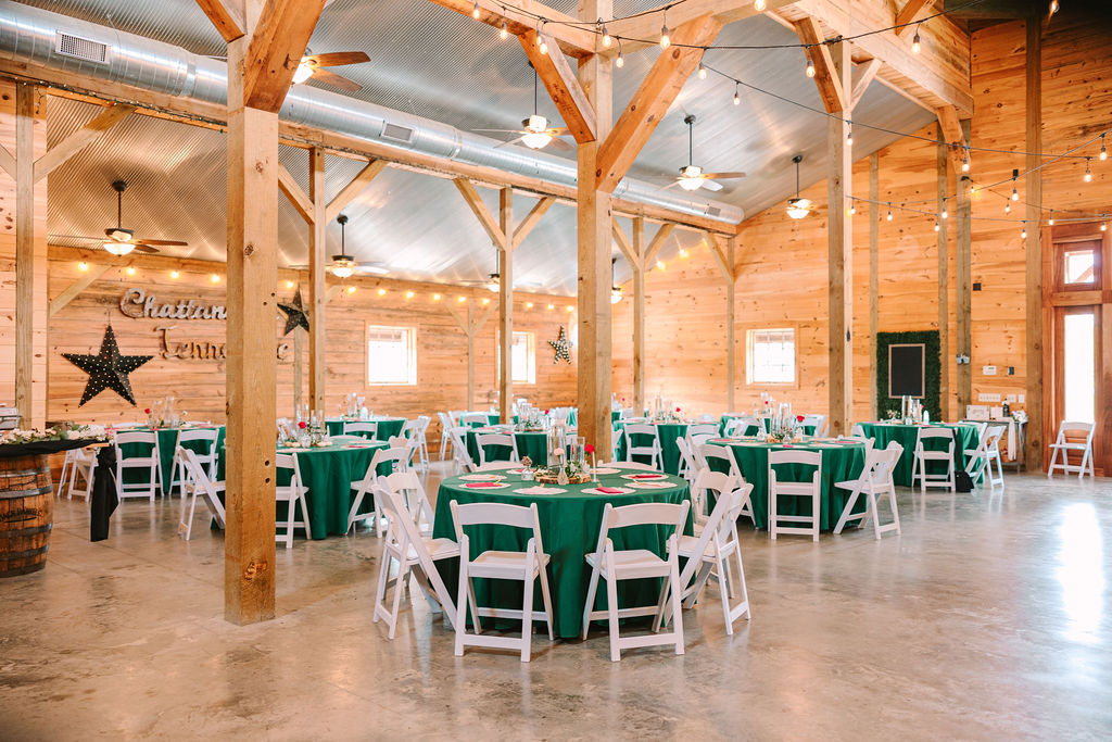 Kate & Josh’s Covey Creek barn reception set with emerald tables, string lights, and Chattanooga neon