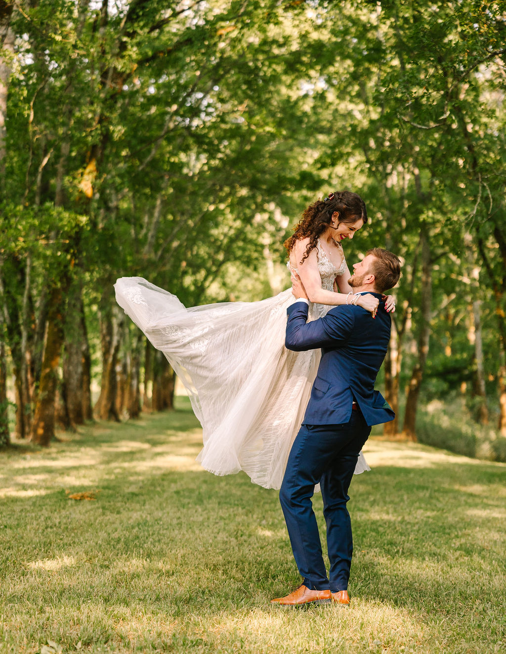 Josh lifts Kate of Kate & Josh beneath Covey Creek’s Tunnel of Love canopy, her tulle skirt flying