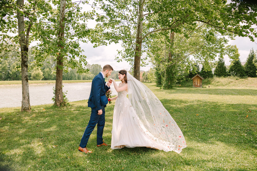 Josh kisses Kate’s hand at Covey Creek; Kate & Josh pose as her floral veil billows by the water