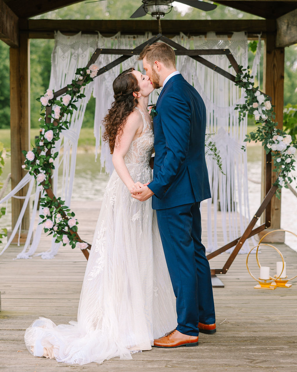 Kate & Josh share a first kiss on Covey Creek’s Pond dock under a macrame hexagonal floral arch