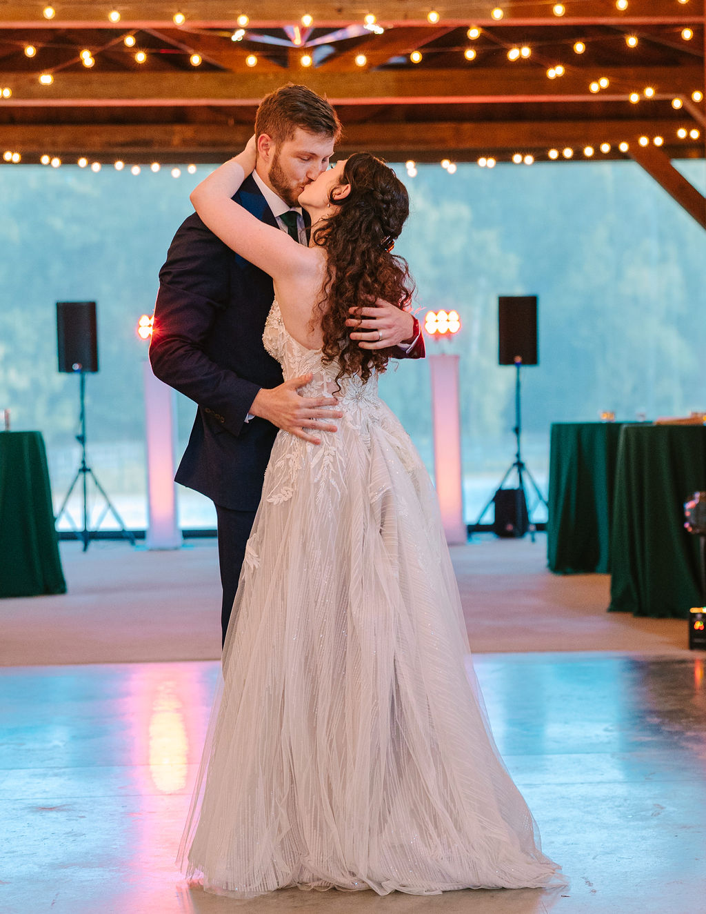 Kate & Josh share a first-dance kiss at Covey Creek under Edison string lights in the pavilion