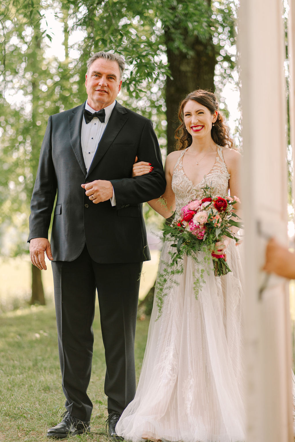 Kate walks the aisle with her father at Covey Creek for Kate & Josh’s wedding, pink bouquet raised