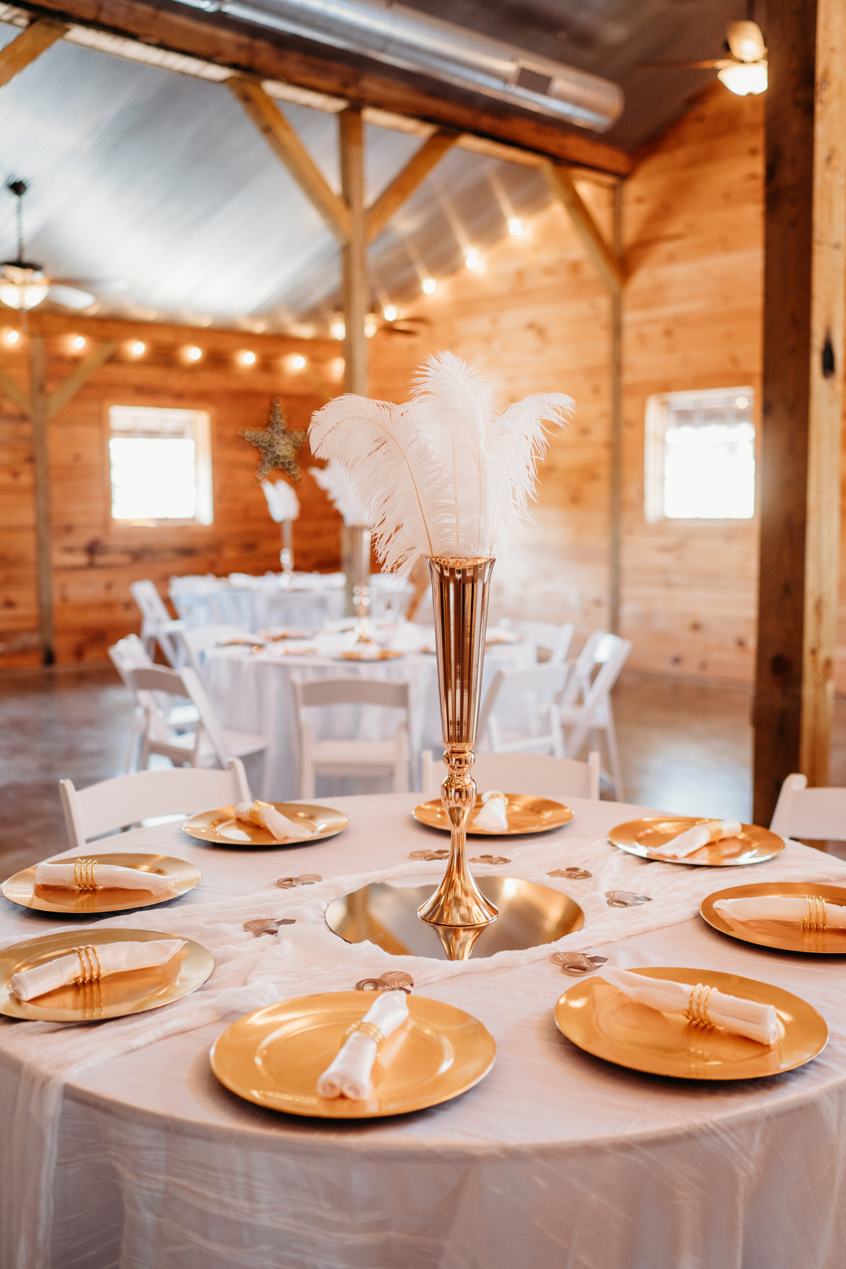 Gold chargers and ostrich-feather gold vase centerpiece at Levi & Billy’s Covey Creek reception table