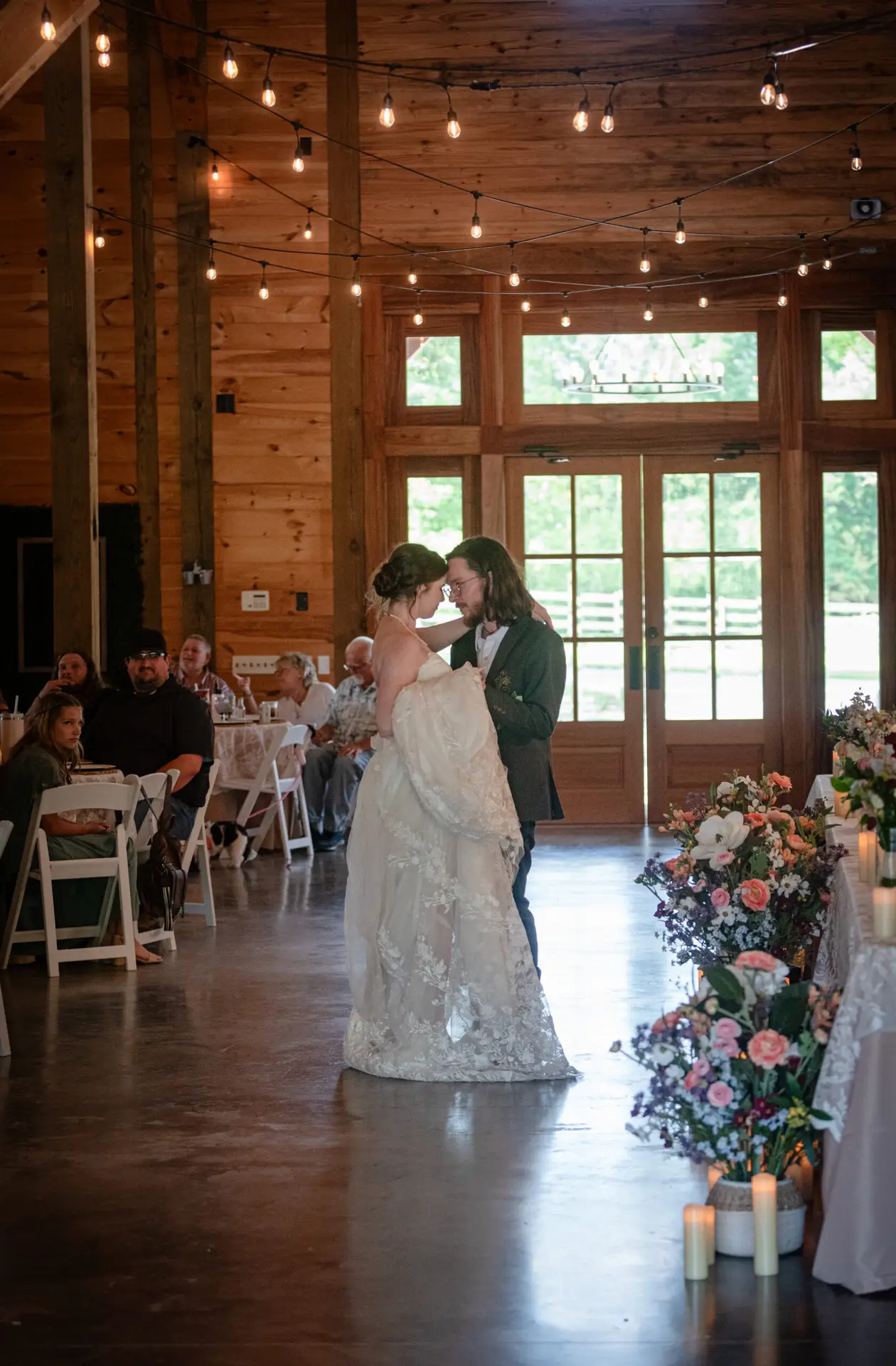 Rachael & Ben share a forehead-touch first dance in the candlelit barn reception at Covey Creek.