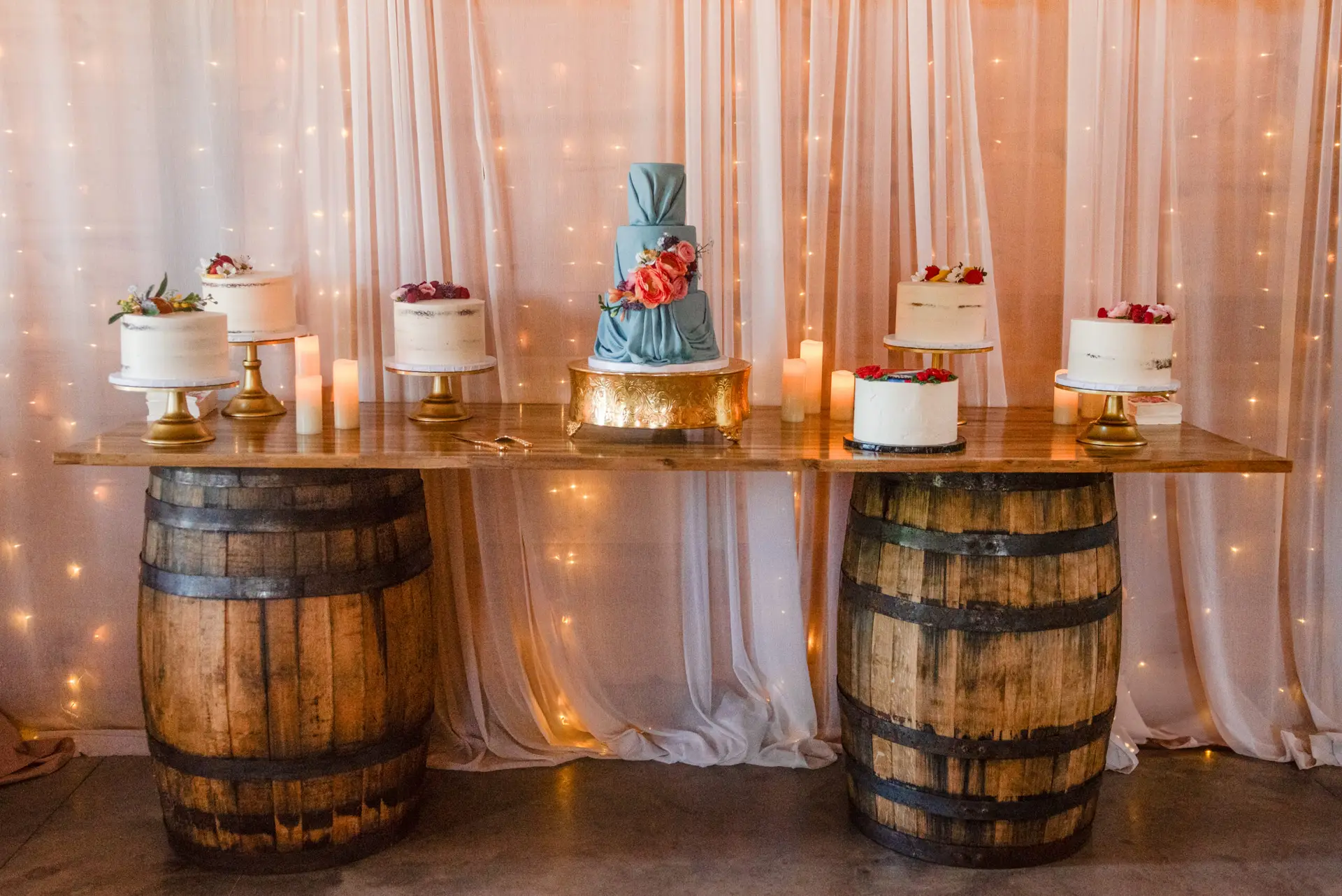 Dusty-blue tiered cake and mini cakes on whiskey barrels for Rachael & Ben at Covey Creek.