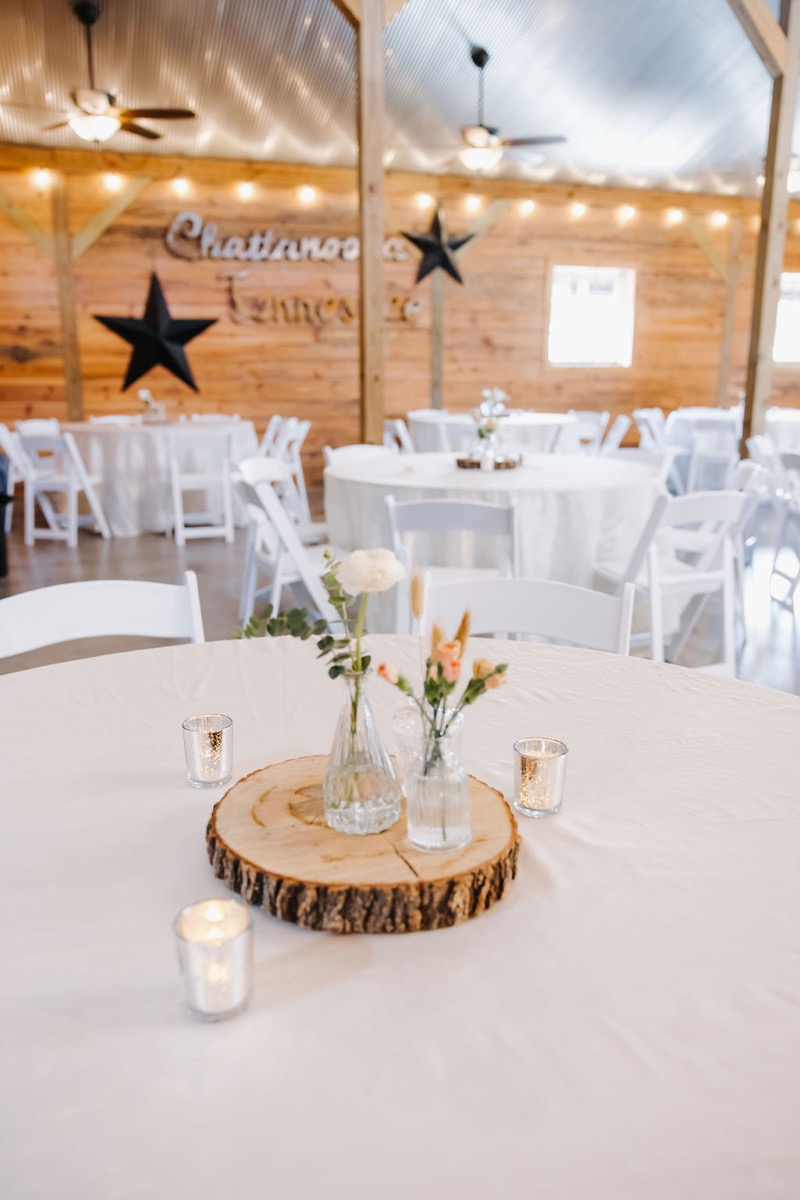 Alexis & Logan reception tables face the Chattanooga Tennessee wood wall with stars at Covey Creek