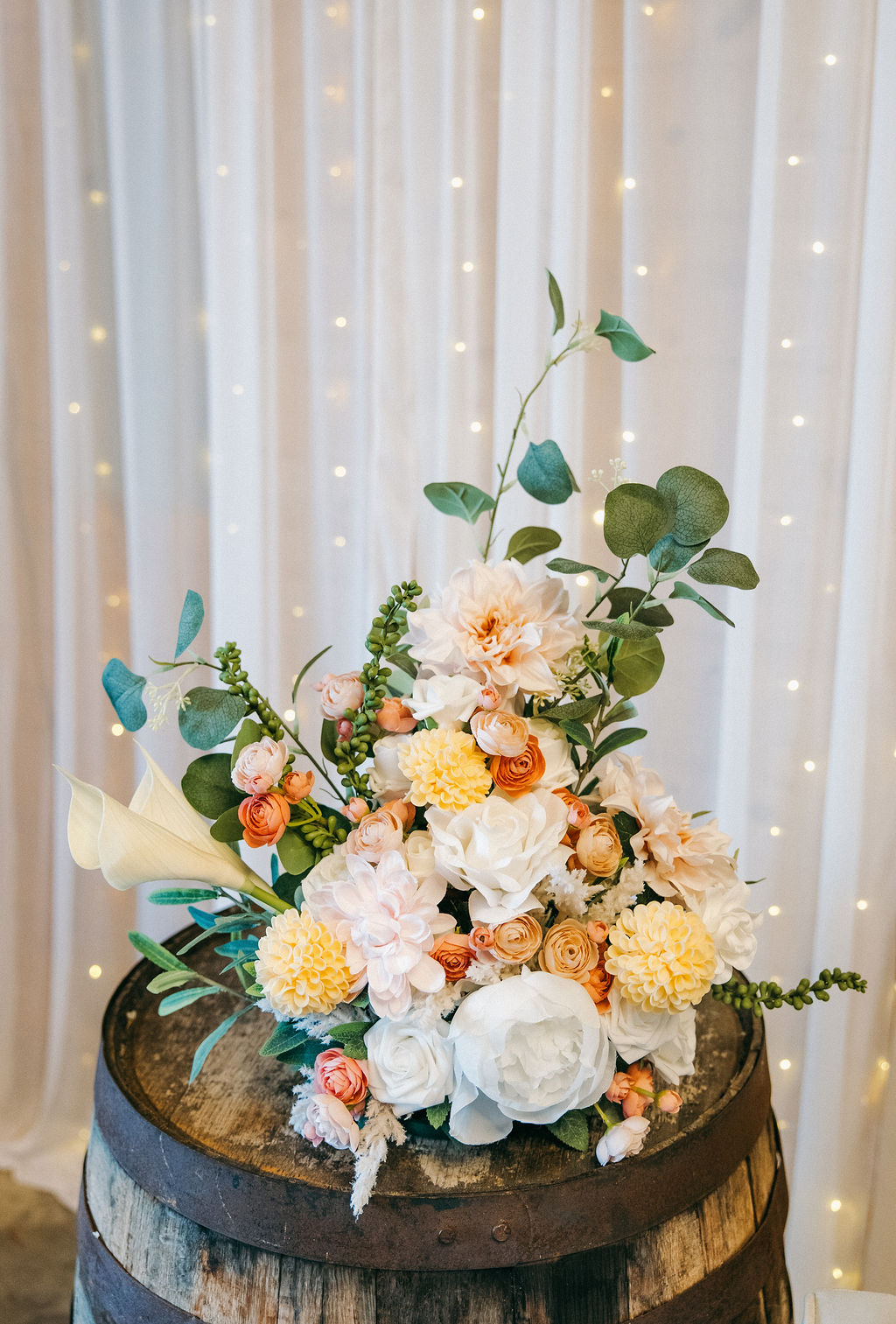 Amanda & Stephen’s peach-and-white barrel centerpiece with calla lilies and fairy lights at Covey Creek
