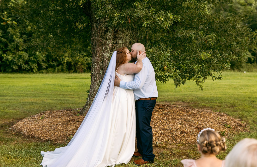 Amanda & Stephen share their first kiss under Covey Creek’s Tunnel of Love oak during the ceremony