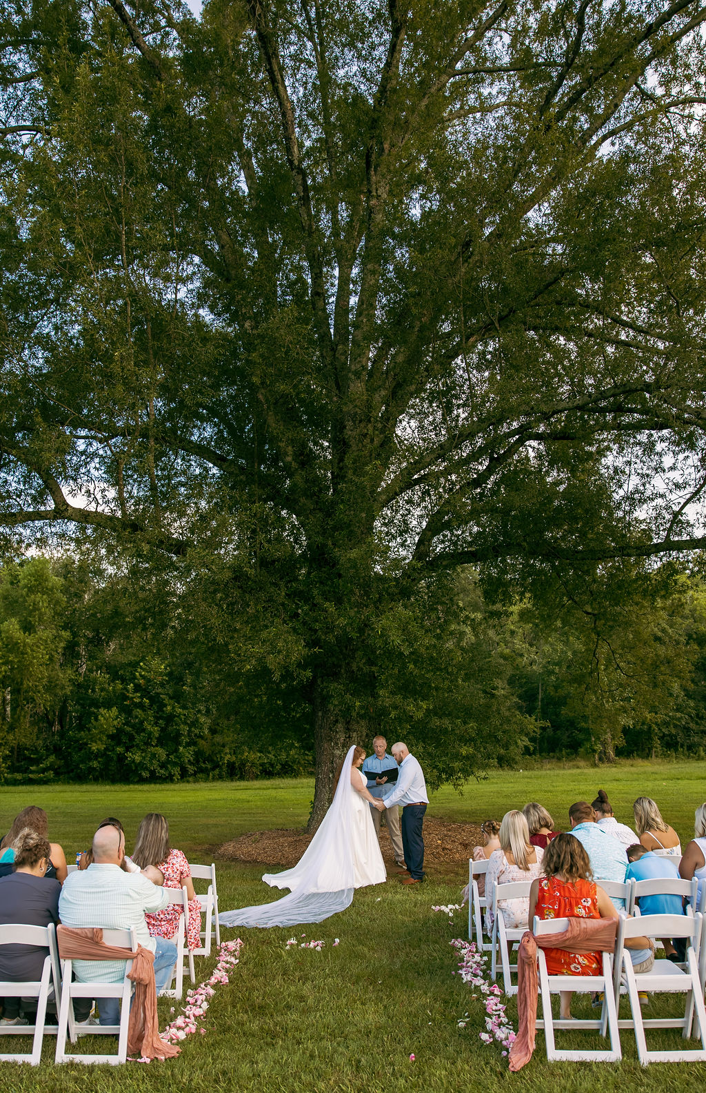 Amanda & Stephen stand at the altar under Covey Creek’s Tunnel of Love oak before seated wedding guests