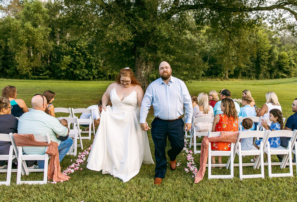 Amanda & Stephen recess down the petal-lined aisle at Covey Creek’s Tunnel of Love after their ceremony