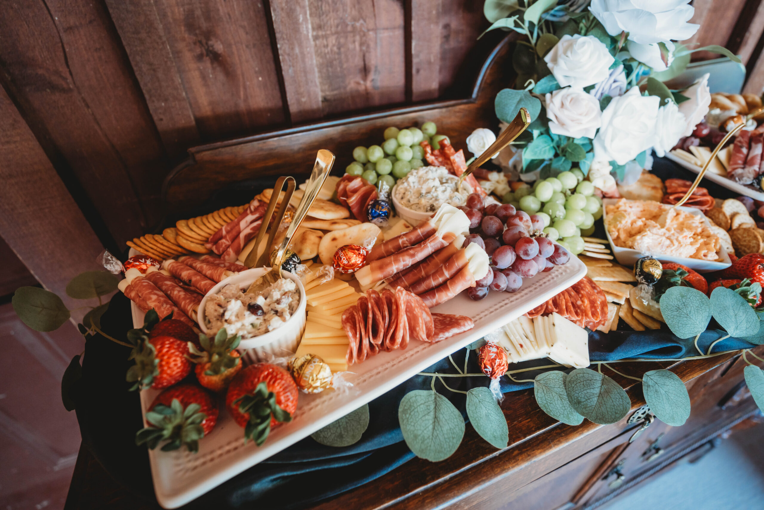 Charcuterie board with meats, cheeses, grapes, and florals for Anna & Jaden's reception at Covey Creek.