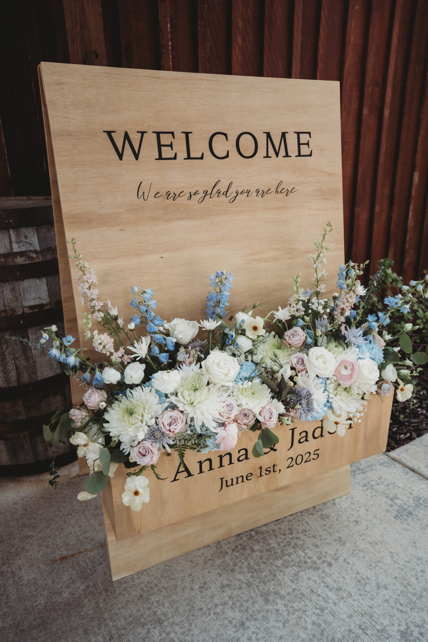 Wooden welcome sign for Anna & Jaden dated June 1st 2025, with pink and blue florals at Covey Creek.