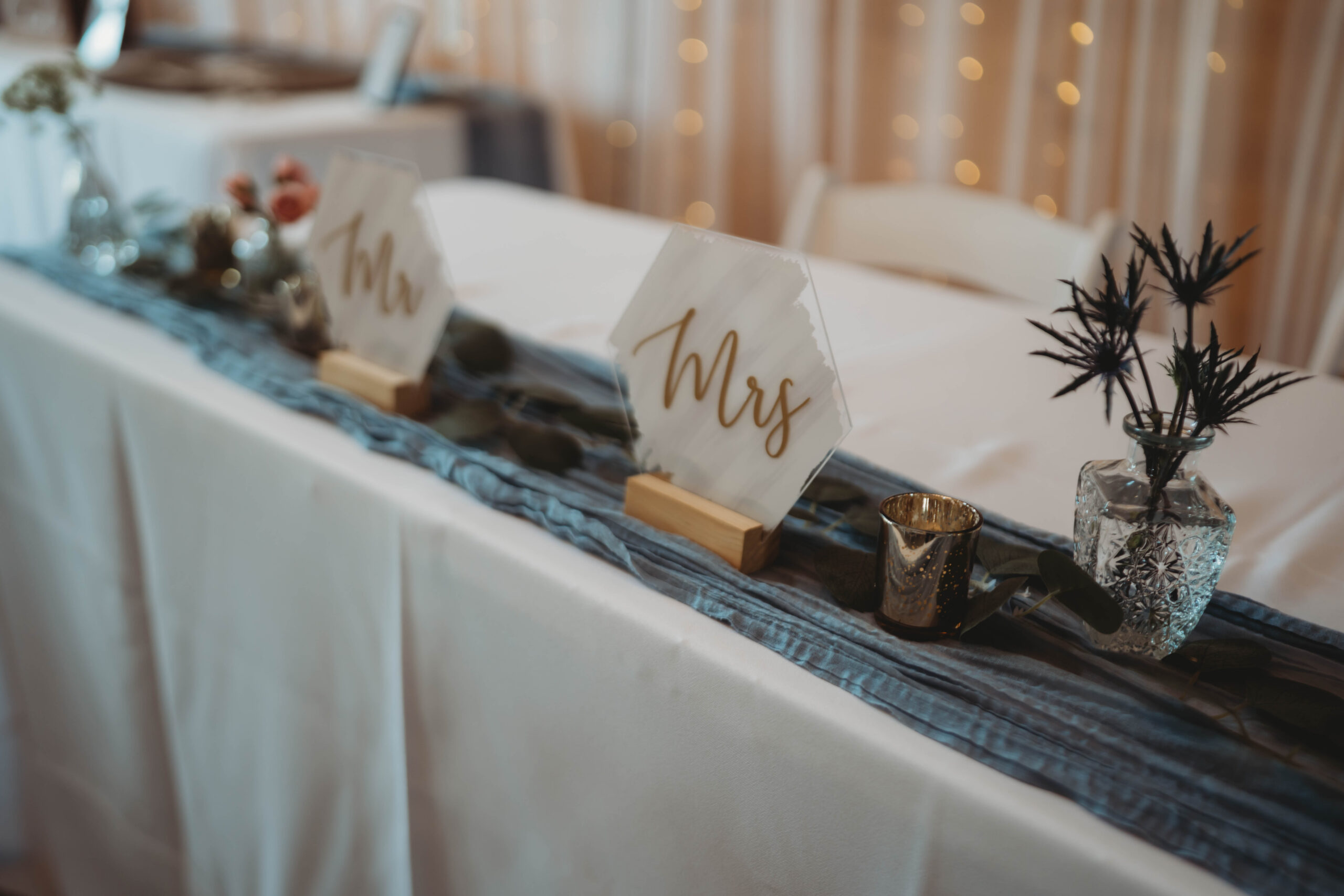 Gold Mr. and Mrs. signs sit with eucalyptus on Anna & Jaden's sweetheart table at Covey Creek.