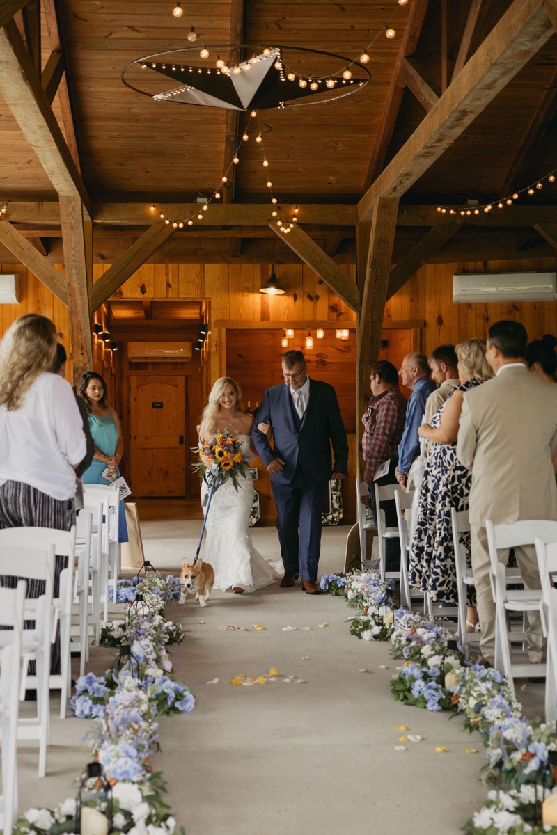 Brianna & Michael's processional: father escorts her as their corgi leads the pavilion aisle at Covey Creek.