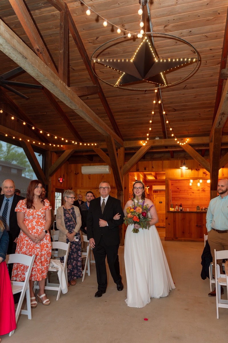 Caitlin & Daniel: bride processes the barn aisle with her father under a lit star at Covey Creek