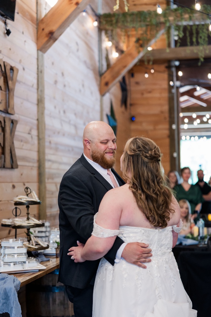 Carly & Lucas share their first dance under string lights during the indoor reception at Covey Creek