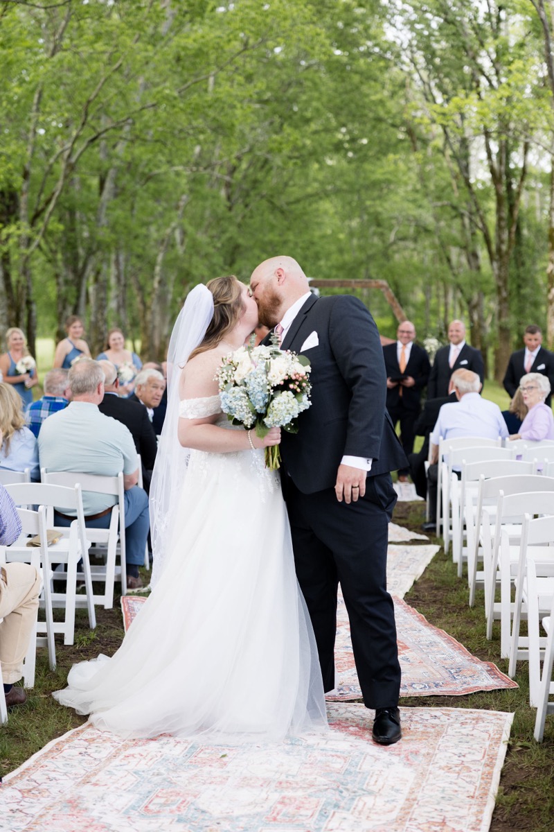 Carly & Lucas share a first kiss on the Tunnel of Love aisle after their ceremony at Covey Creek