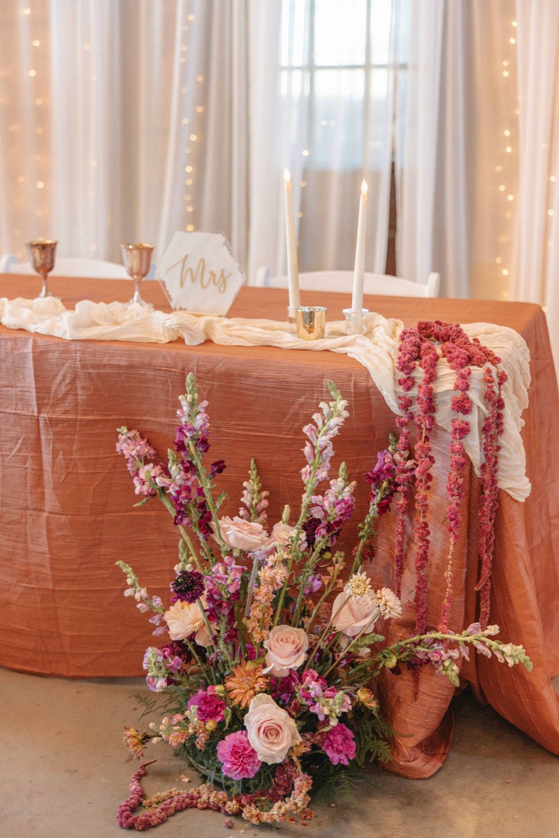 Claire & Jacob sweetheart table with terracotta linen, candles, and floor florals at Covey Creek