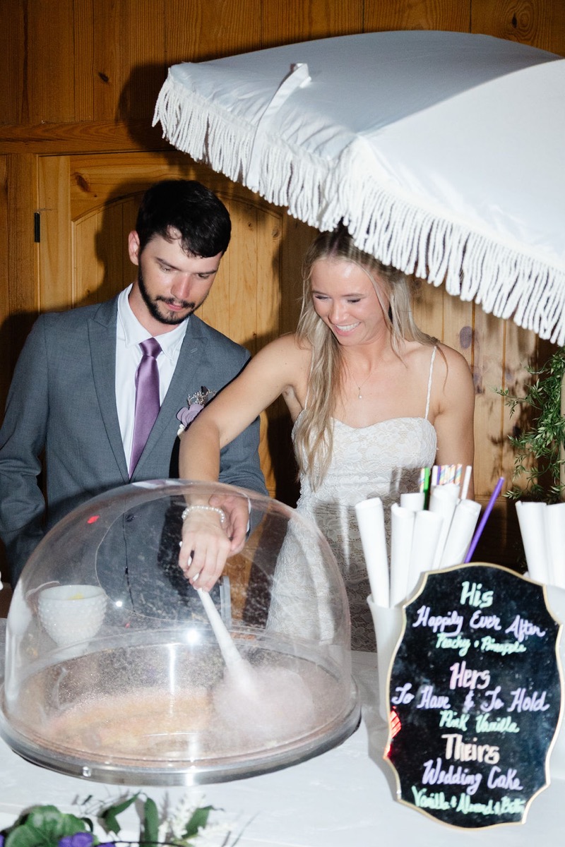 Courtney & Brett spin pink cotton candy at their reception dessert station inside Covey Creek