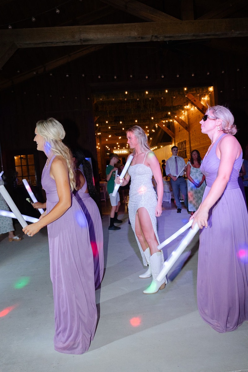Courtney & Brett: bride dances with bridesmaids in cowboy boots and glow sticks at Covey Creek