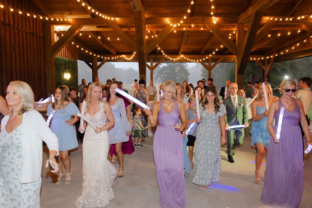 Courtney & Brett: bride leads bridesmaids with glowing LED sticks through the lit Covey Creek pavilion