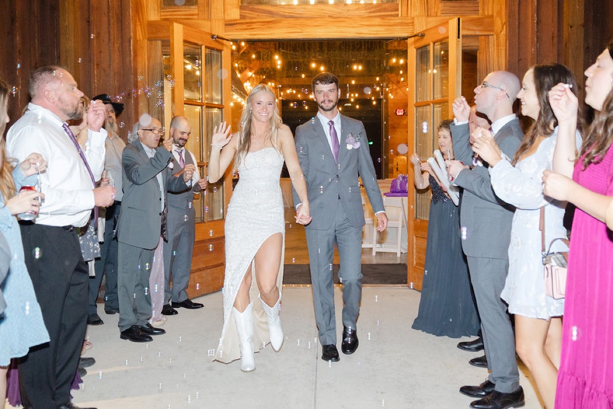 Courtney & Brett exit through barn doors as guests blow bubbles at their Covey Creek send-off