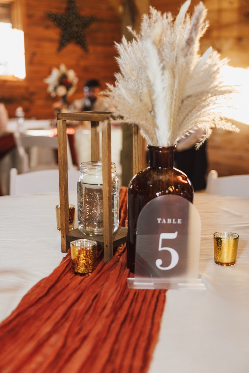 Table 5 centerpiece with pampas, lantern, and terracotta runner for Danika & Troy at Covey Creek