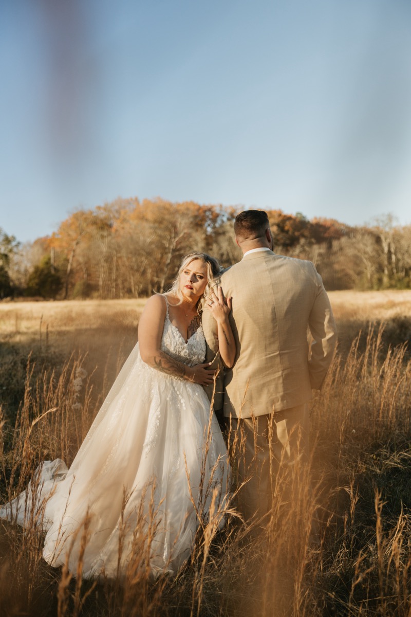 Danika & Troy share a close portrait; she leans on his shoulder in golden grass at Covey Creek