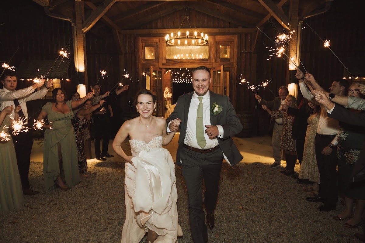 Emily & Bryan run hand-in-hand through a sparkler send-off on the Patio outside the reception at Covey Creek.