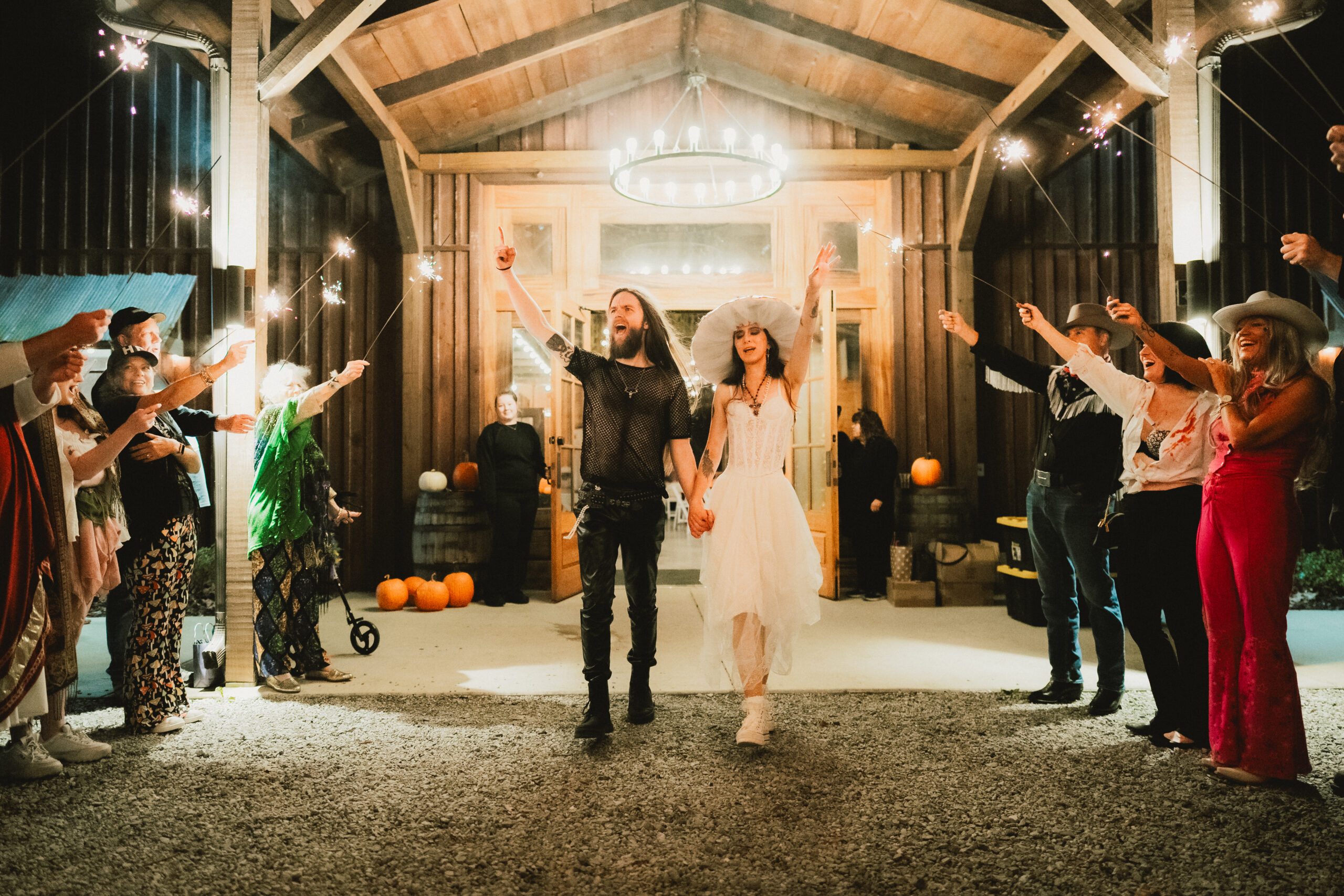 Erin & Baxter cheer through a sparkler send-off from the chandelier-lit barn at Covey Creek