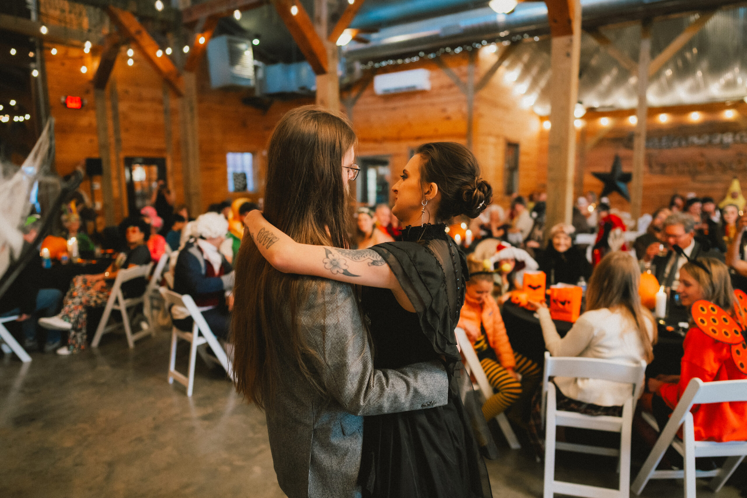 Erin & Baxter slow dance in the barn among pumpkin tables and costumed guests at Covey Creek