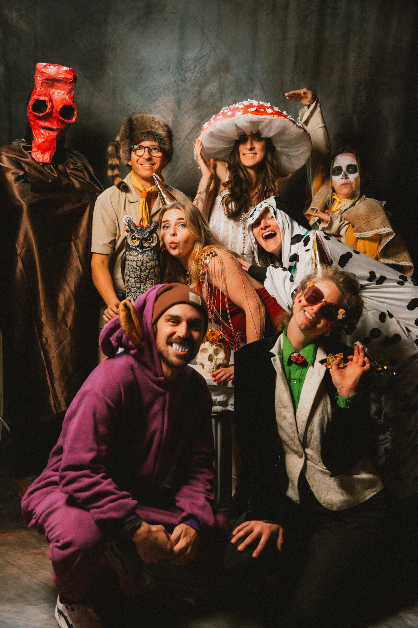 Guests in mushroom hats, cow onesies, and creature costumes pose at Erin & Baxter's Covey Creek wedding