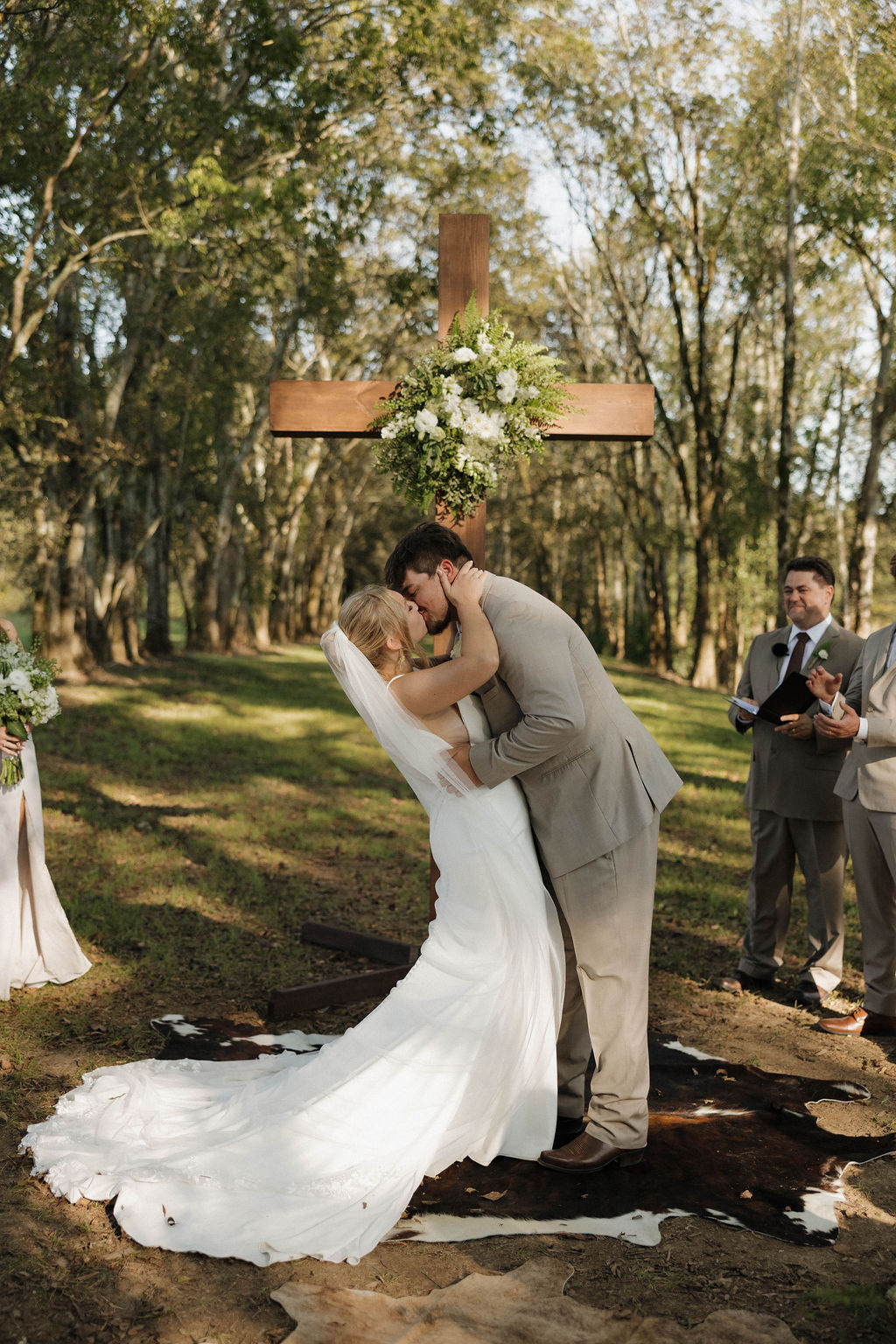 Joseph dips Hailey for a kiss before a flowered wooden cross at Hailey & Joseph's Covey Creek ceremony