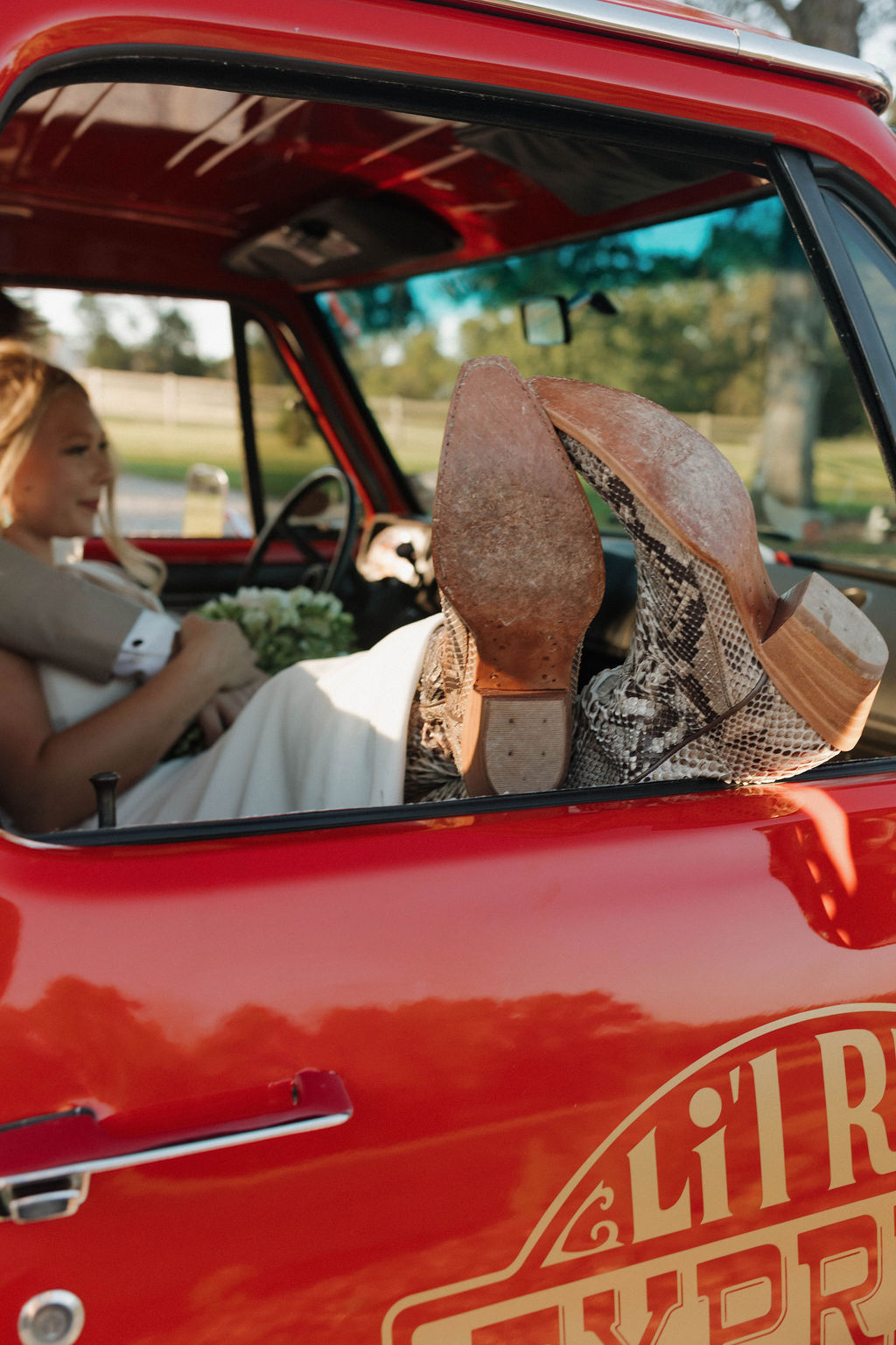 Snakeskin boots on a red vintage truck with Hailey & Joseph visible in the cab at Covey Creek