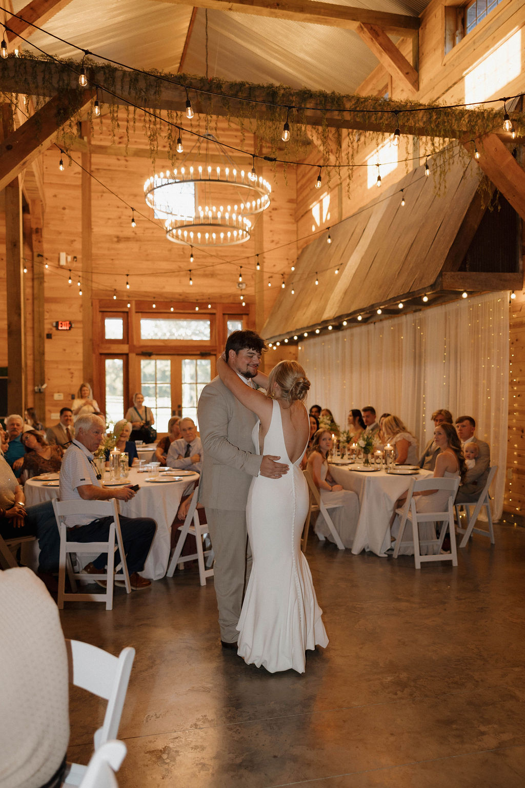 Hailey & Joseph share their first dance under Edison lights in the Covey Creek barn reception