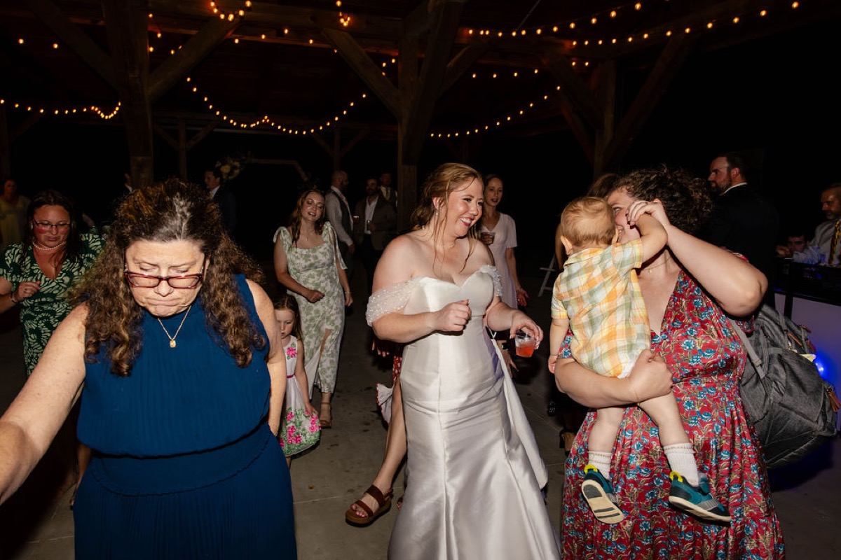 Hannah dances under pavilion string lights with guests at night at Covey Creek, Hannah & Nicholas.