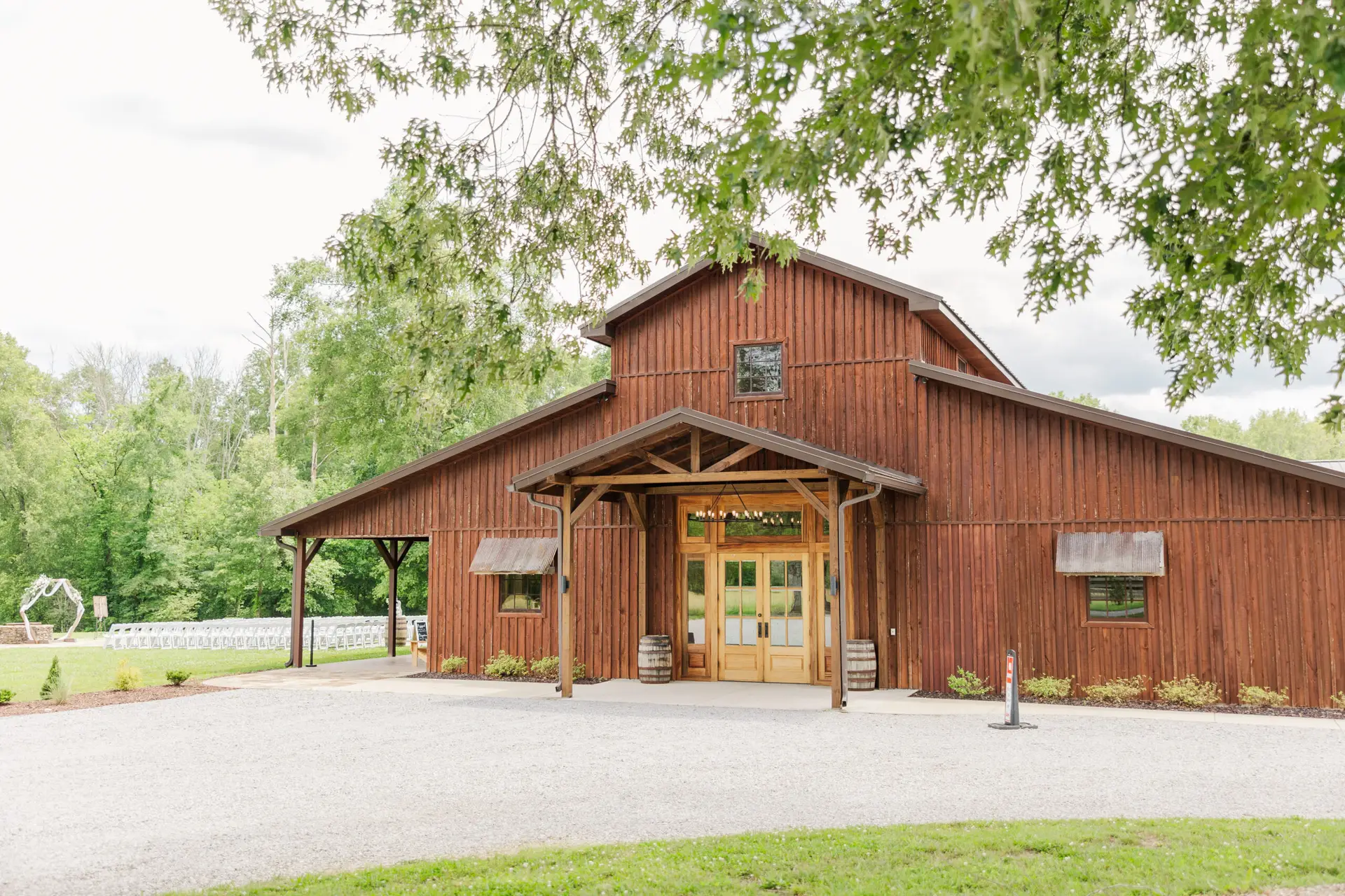 Covey Creek barn exterior with patio and outdoor ceremony chairs set for Hannah & Ryan's day.