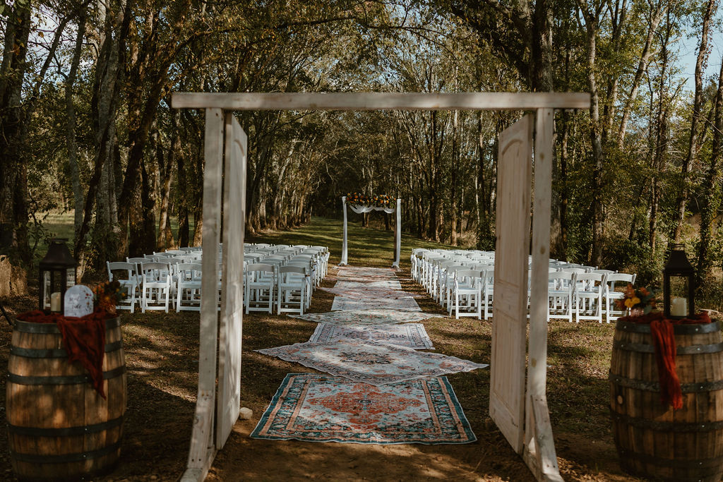 JJ & Will Tunnel of Love ceremony setup with wooden doors, rug aisle, and floral arbor at Covey Creek