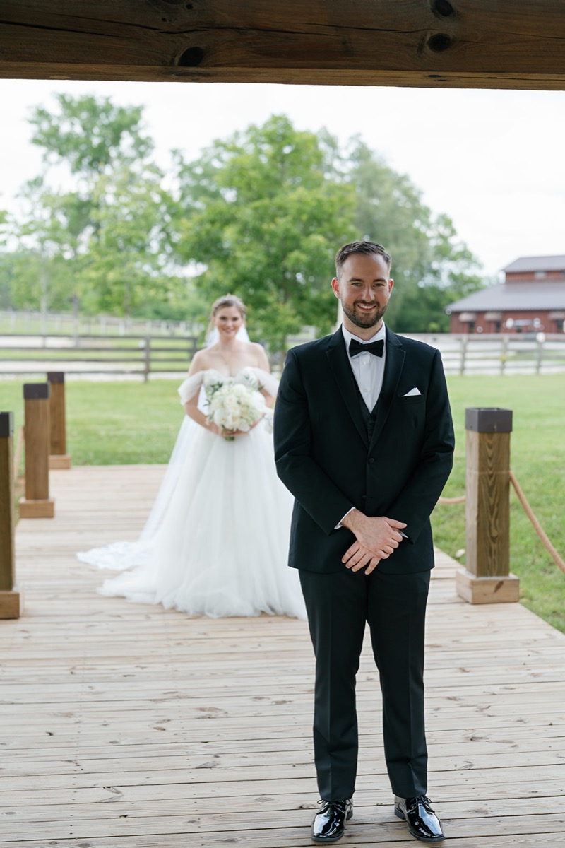 Katelyn & Josh first look at Covey Creek: Josh waits on the wooden Pond walkway as she approaches