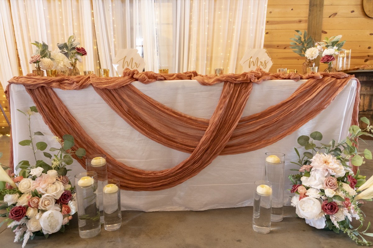 Kristen & Dalton sweetheart table with Mr and Mrs signs, floor florals, and floating candles at Covey Creek