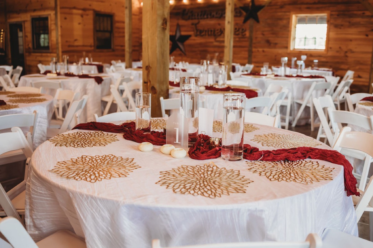 Round guest table with gold placemats and burgundy runner set for Lauren & Alex at Covey Creek