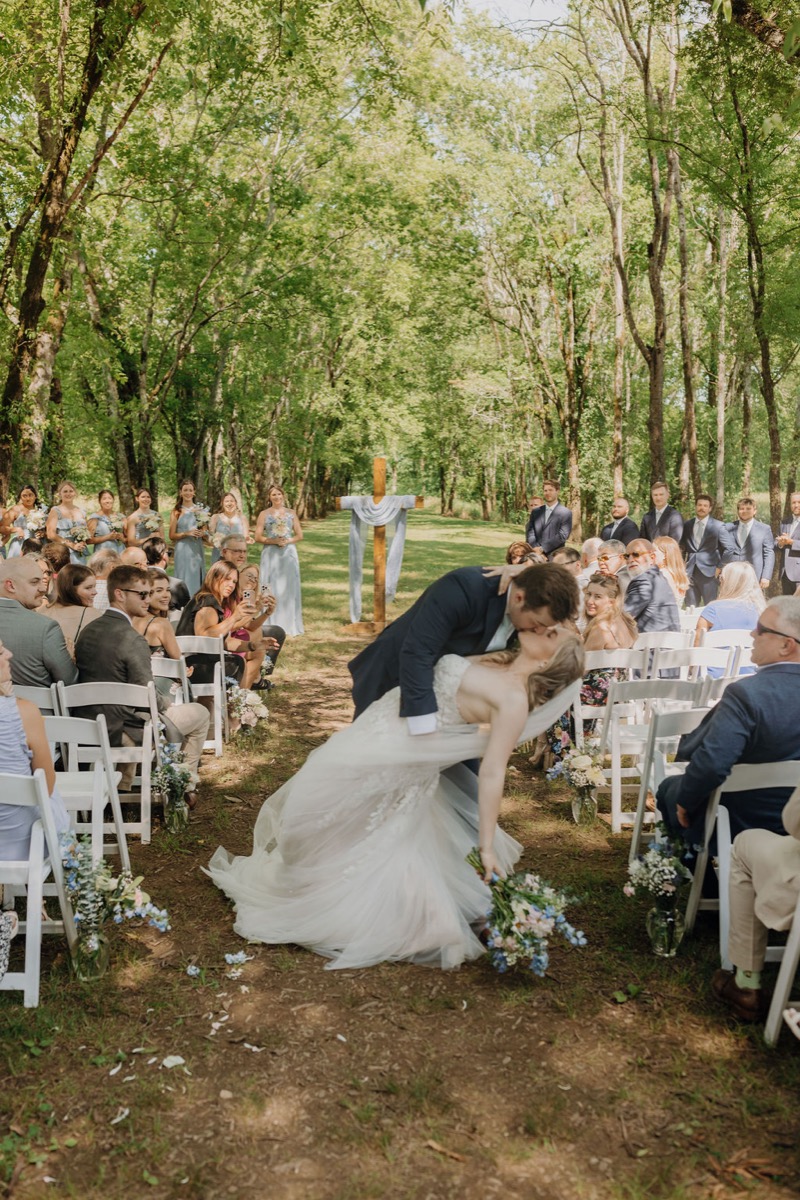 Gordon dips Leah for a kiss in Covey Creek’s Tunnel of Love aisle after their outdoor ceremony