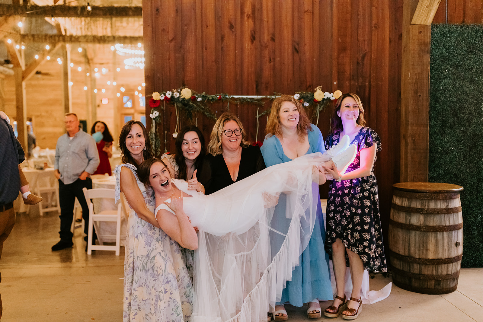 Friends lift Leslie horizontally as she laughs during Leslie & Timothy Covey Creek reception