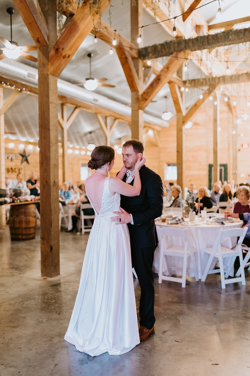 Leslie & Timothy share their first dance under string lights in the Covey Creek barn reception